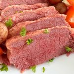 baked corned beef and cabbage with potatoes and carrots on platter