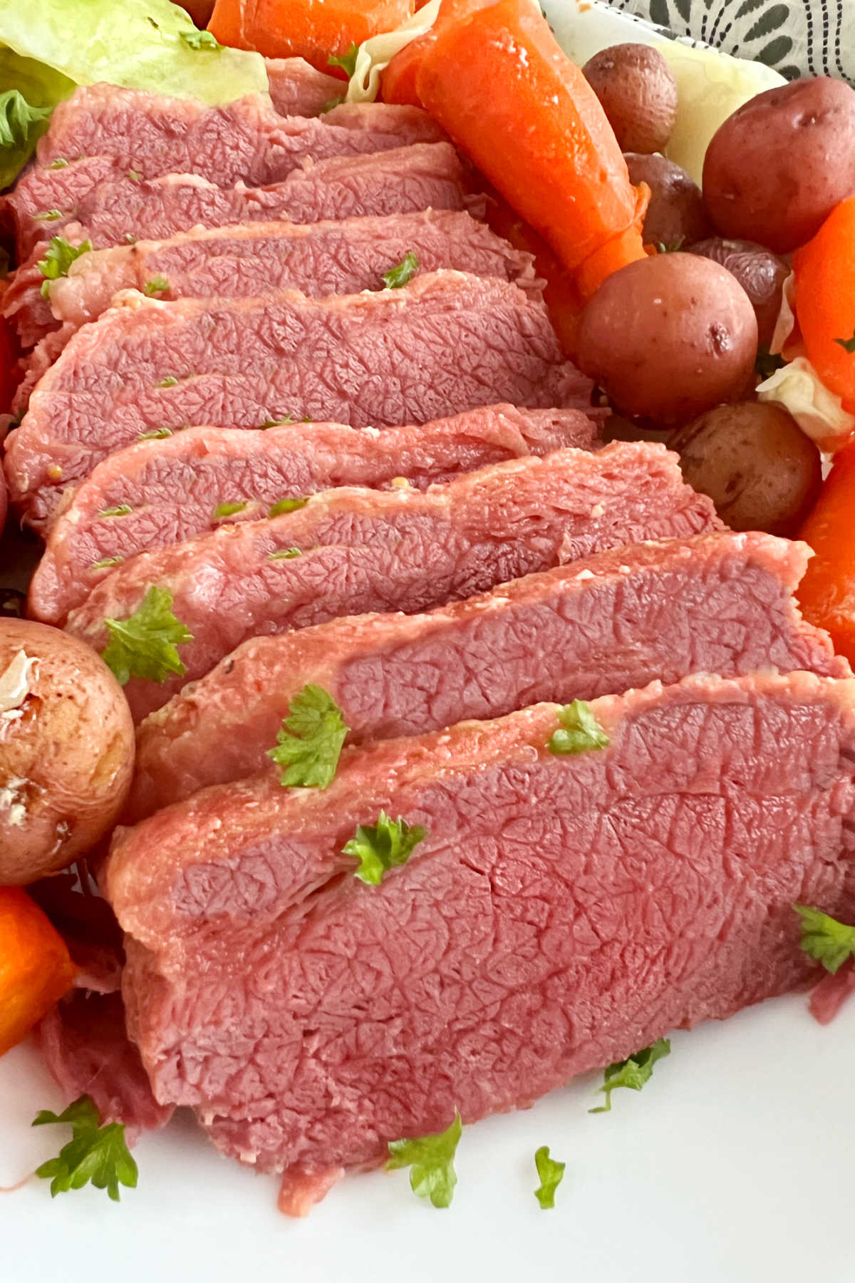 platter of baked corned beef and cabbage with potatoes and carrots
