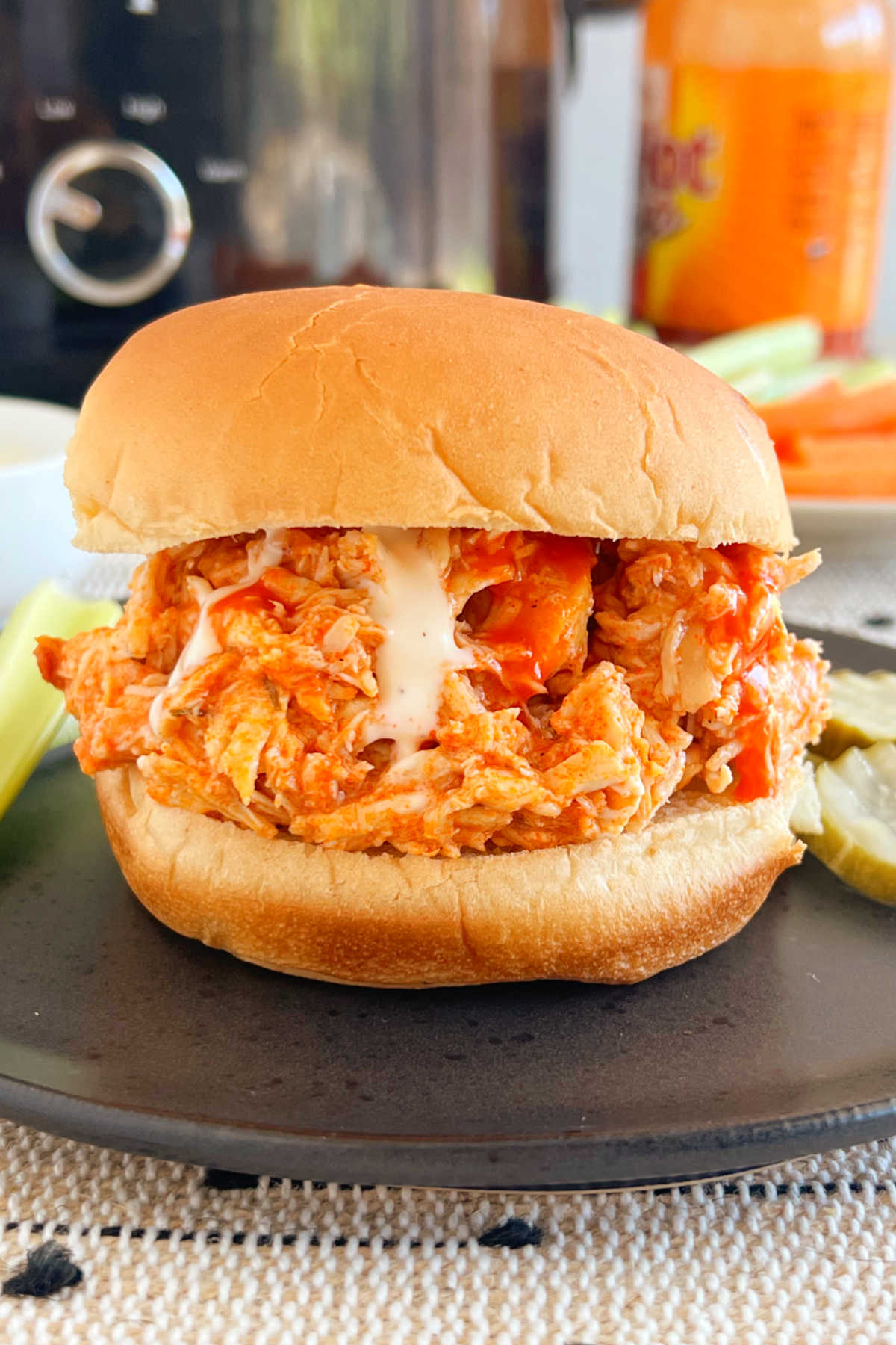 crock pot buffalo chicken sandwiches with shredded chicken on a bun