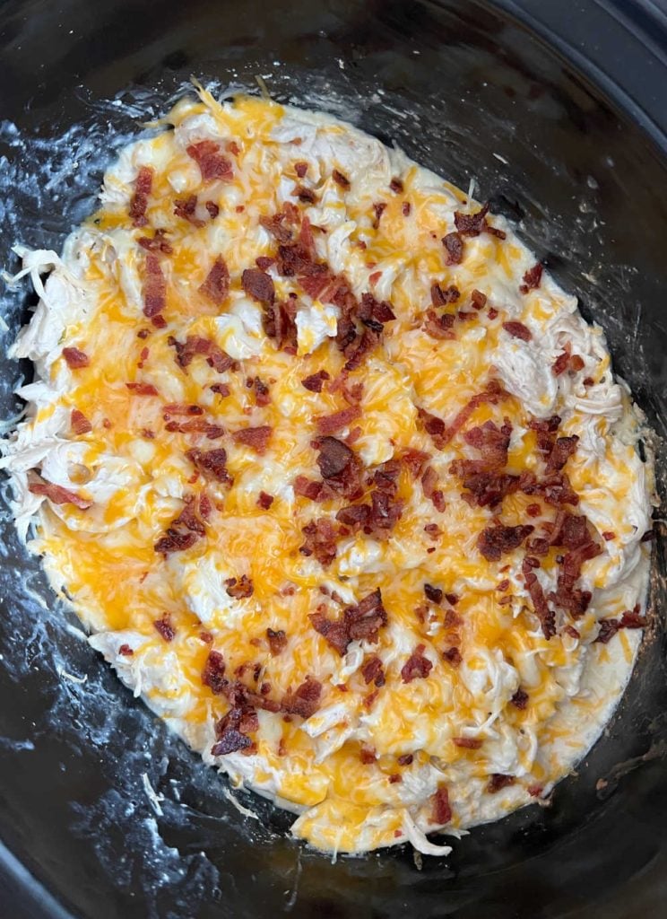 shredded crack chicken with cheddar cheese and bacon in crock pot