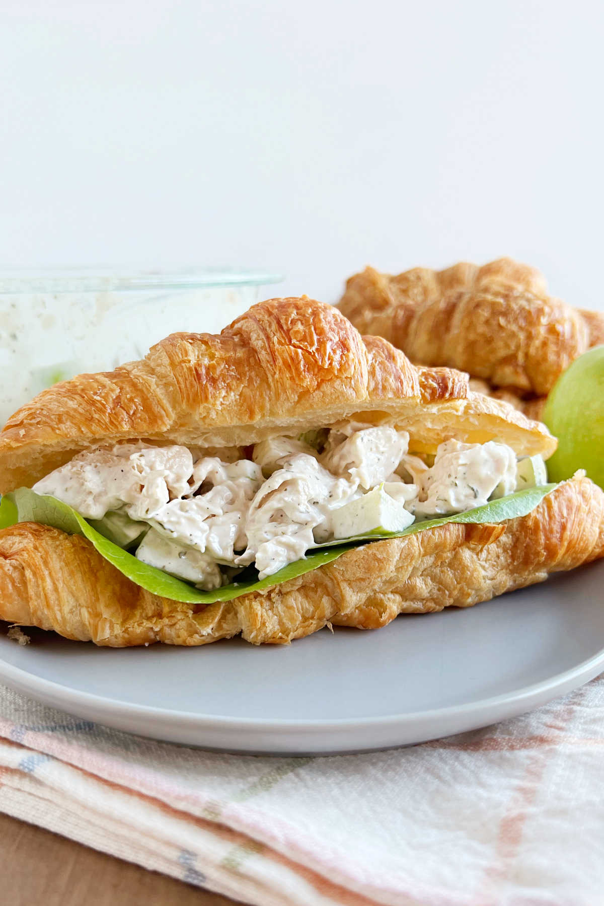 lemon chicken salad with apples in a croissant roll on plate