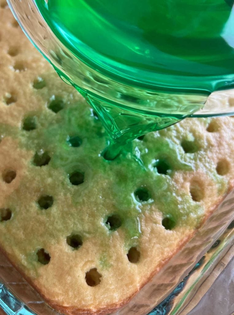 pour lime jello into holes in cake