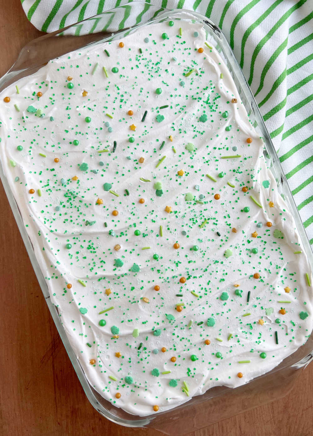 lime jello cake in baking dish with St. Patrick's day sprinkles on top