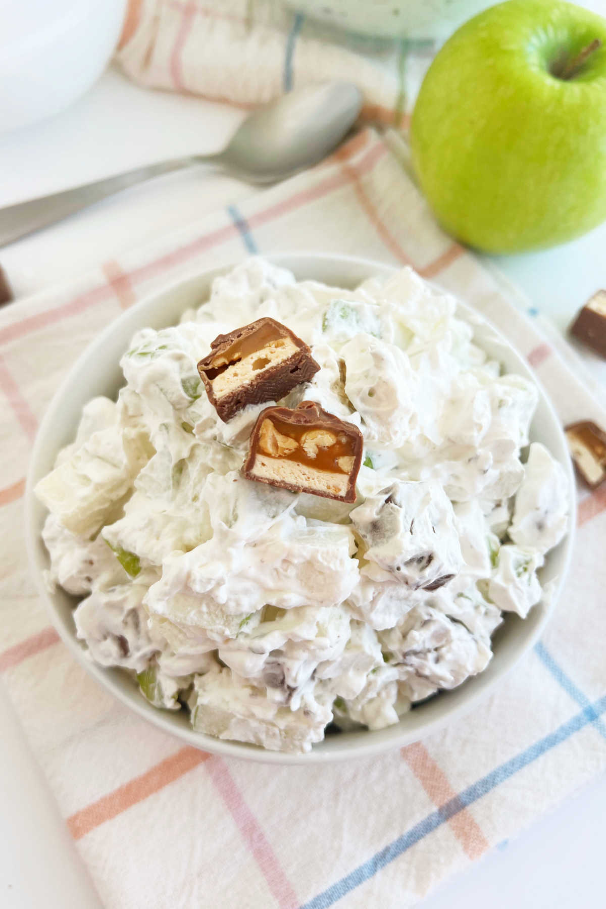 bowl of Snickers apple salad with chopped snickers candy bars and tart green apples