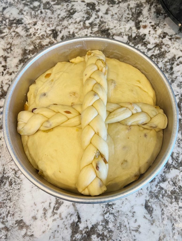 paska dough with raisins and braided cross in 9-inch cake pan