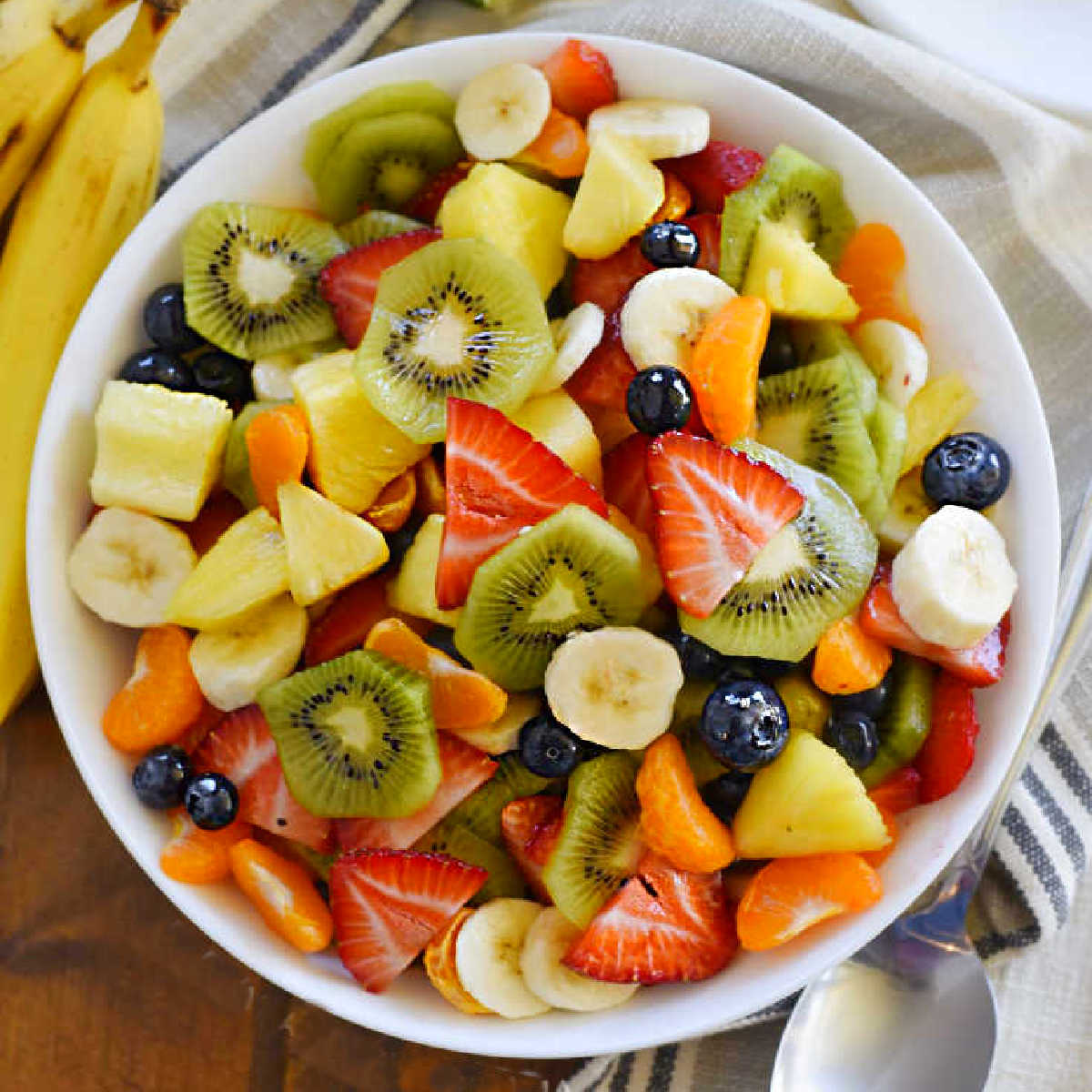 bowl of tropical fruit salad with mandarin oranges, bananas and fresh pineapple