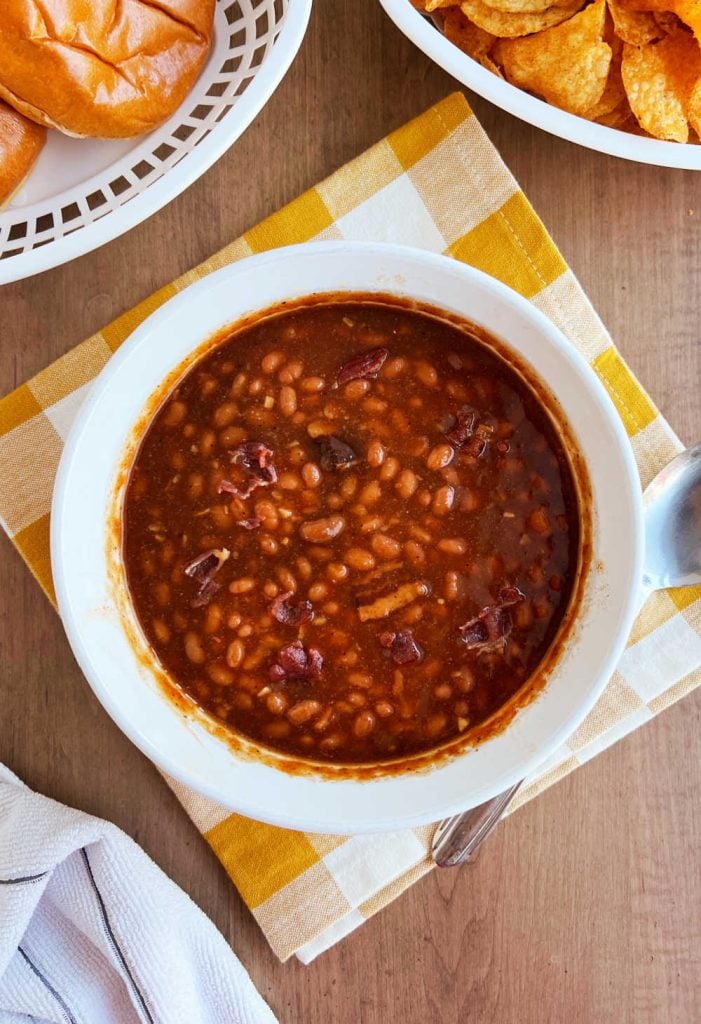 microwaved baked beans with bacon in white casserole dish on table