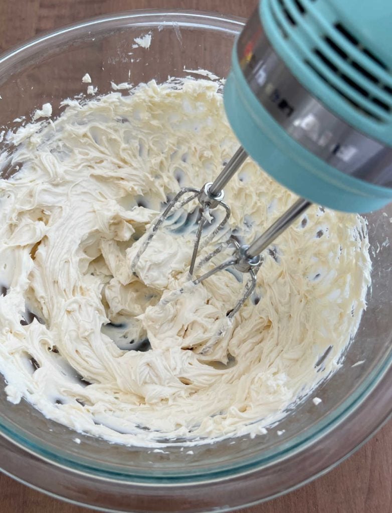 cream cheese and vanilla extract in large bowl with hand mixer