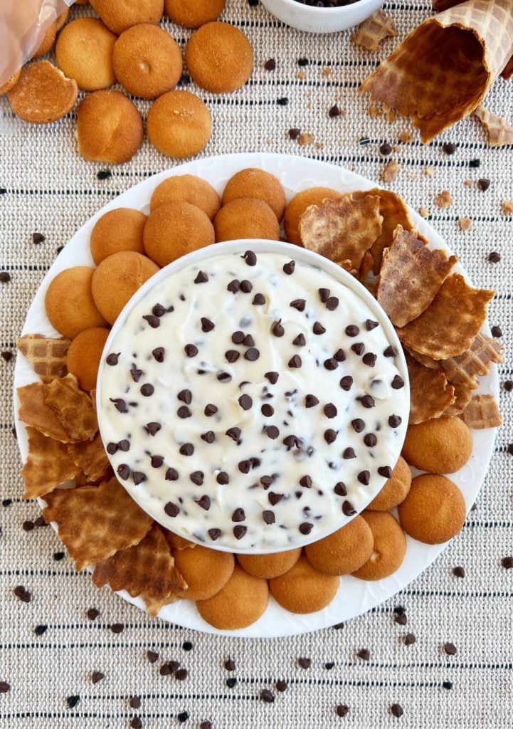 bowl of cannoli dip with mini chocolate chips on platter with dippers