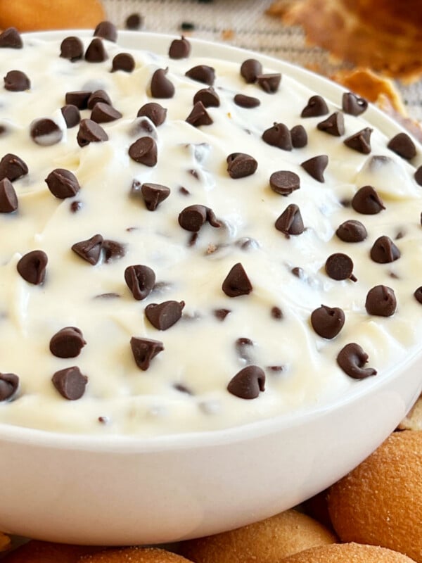 easy cannoli dip with cream cheese and mini chocolate chips in white bowl