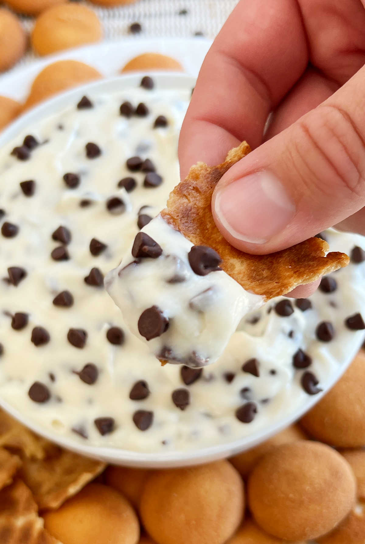 hand holding cannoli dip on waffle cone piece