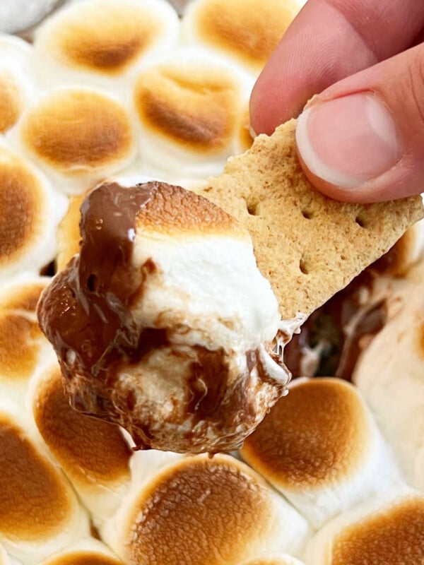 easy smores dip with melted chocolate and gooey marshmallows on a graham cracker