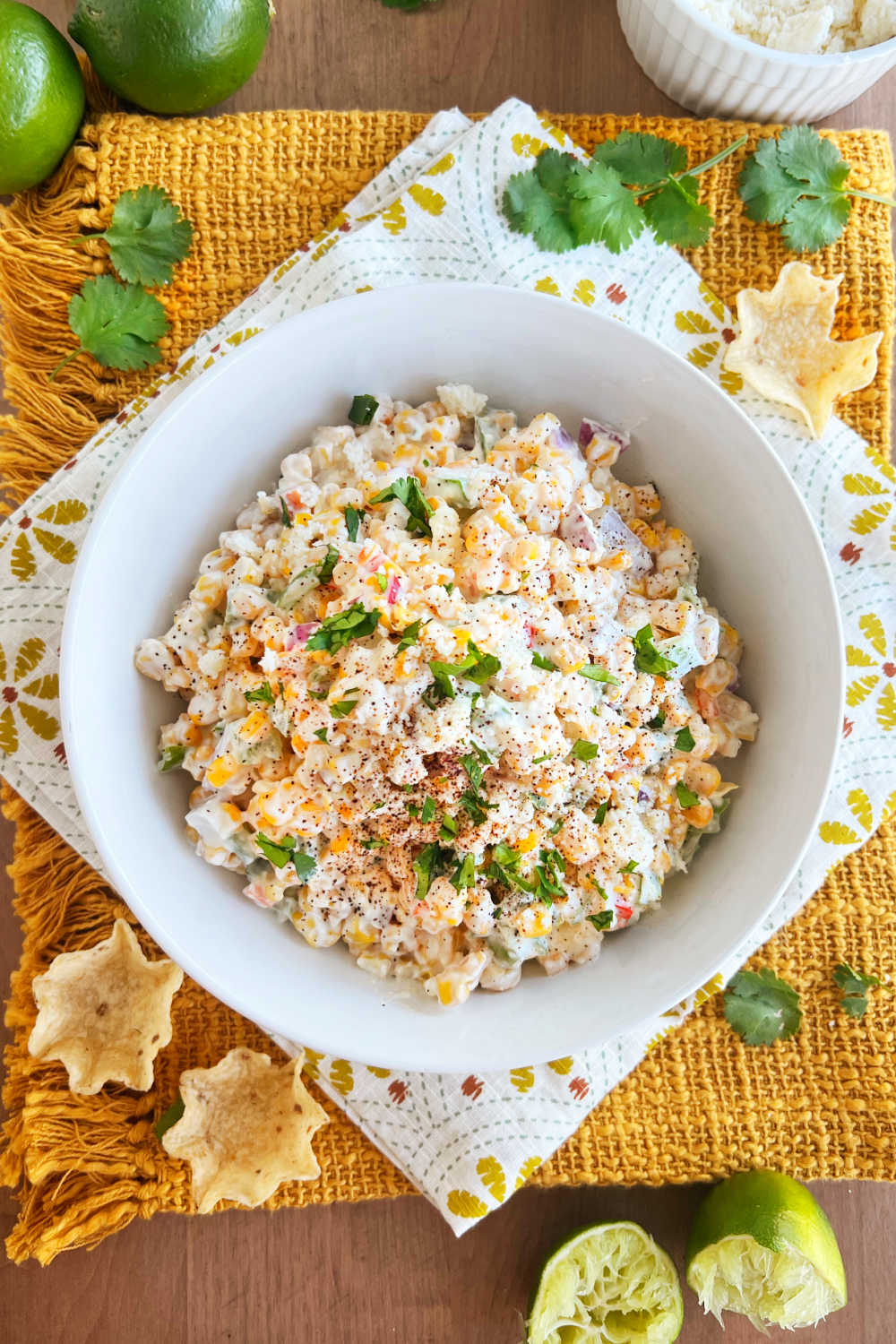 Mexicans street corn salad in a serving bowl topped with cotija cheese and cilantro