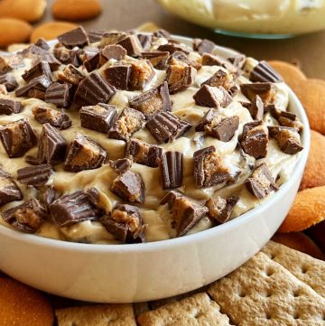 bowl of peanut butter cheesecake dip with mini Reese's cups on top