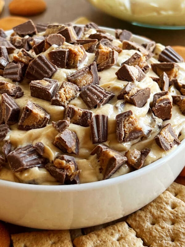 bowl of peanut butter cheesecake dip with mini Reese's cups on top