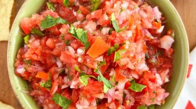 spicy pico de gallo recipe with red onion and cilantro in a green bowl