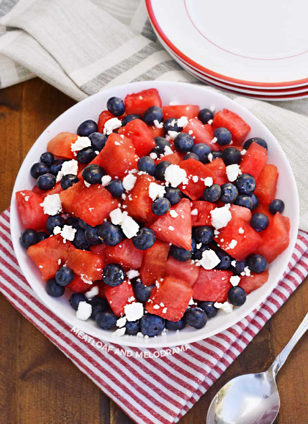 watermelon feta salad with blueberries in a white serving bowl on the table.