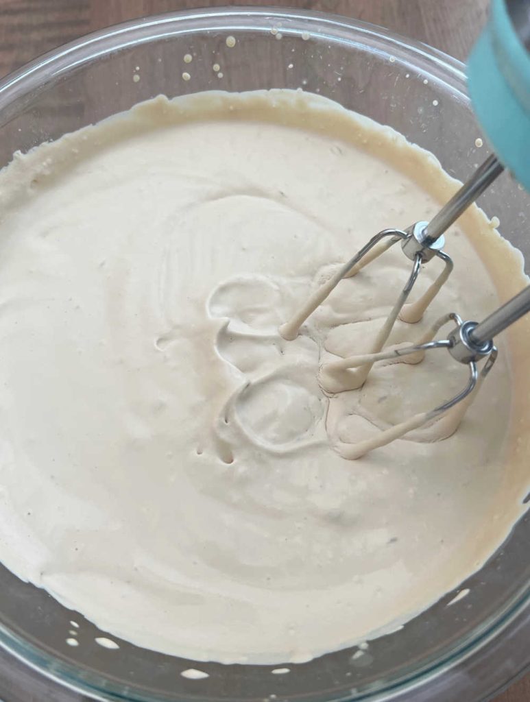 beat heavy whipping cream with electric mixer in mixing bowl