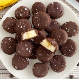 frozen chocolate banana bites with flaked sea salt on a plate
