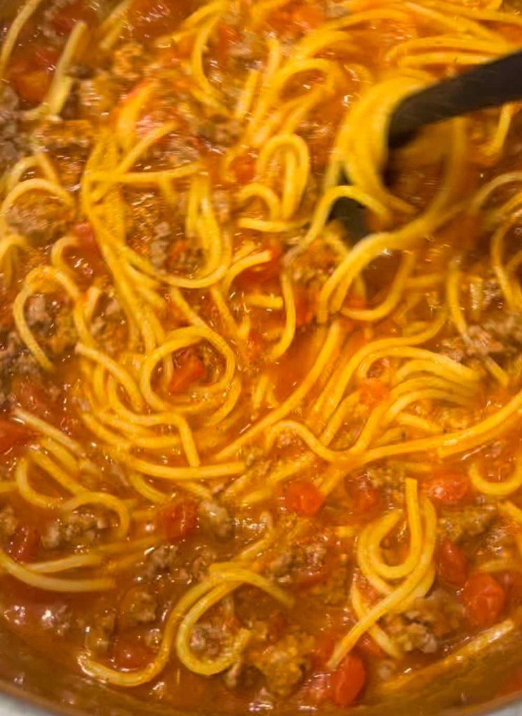stir spaghetti noodles and meat sauce in instant pot