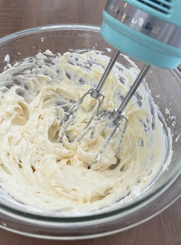 cream cream cheese, vanilla and sugar with electric mixer in mixing bowl