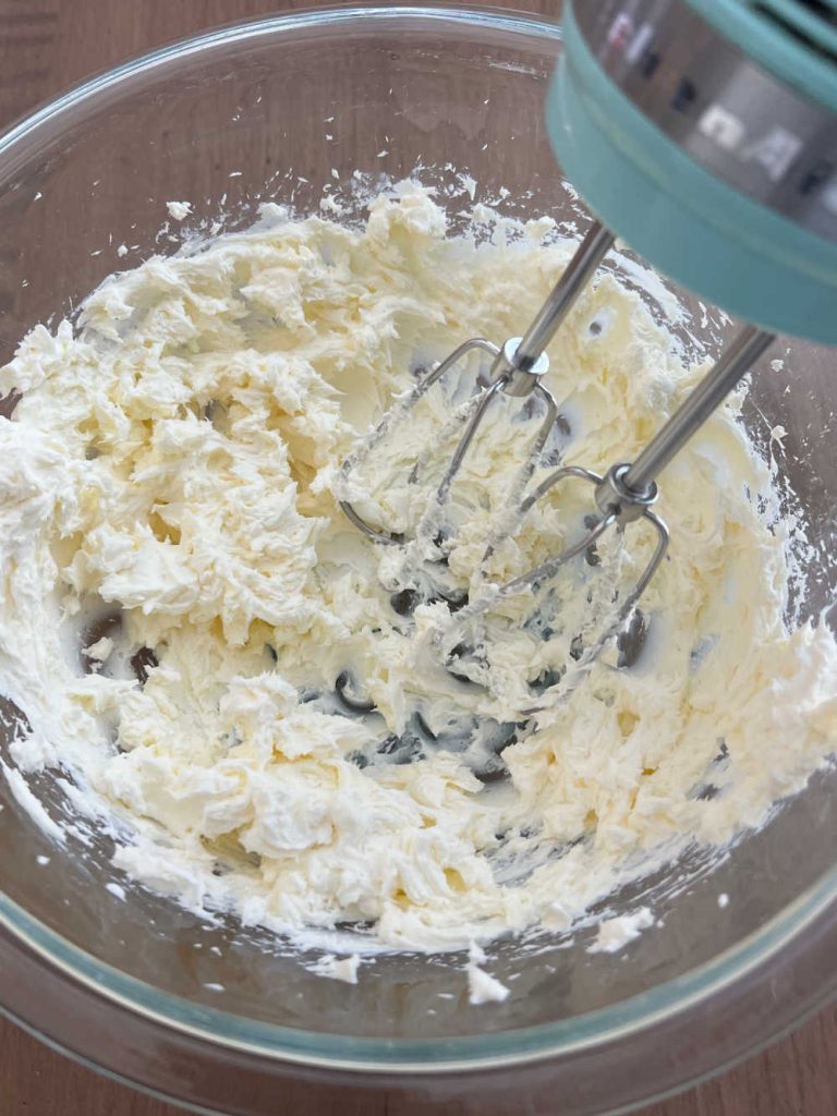 beat cream cheese in mixing bowl with electric mixer