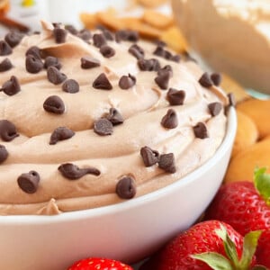 bowl of nutella cheesecake dip with mini chocolate chips and strawberries