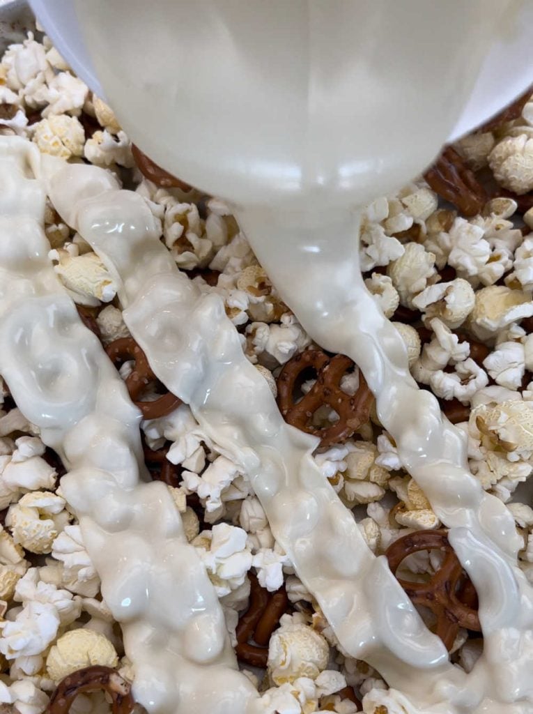 drizzle melted white chocolate over popcorn kernals