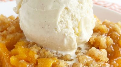 fresh peach crisp without oats topped with scoop of ice cream