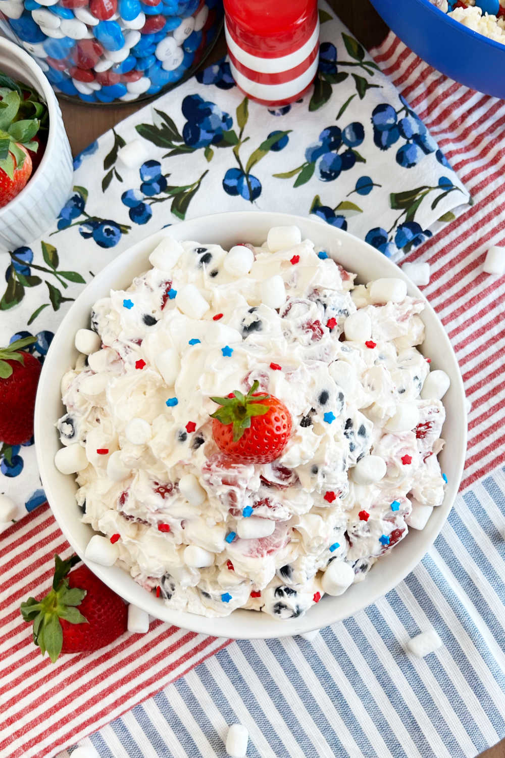 bowl of red white and blue cheesecake salad on fourth of July table