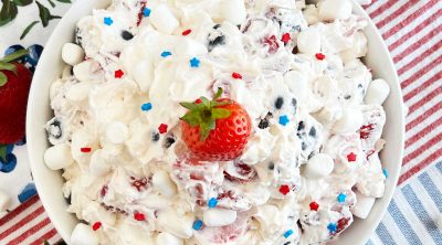 red white and blue cheesecake salad with marshmallows and strawberry on top