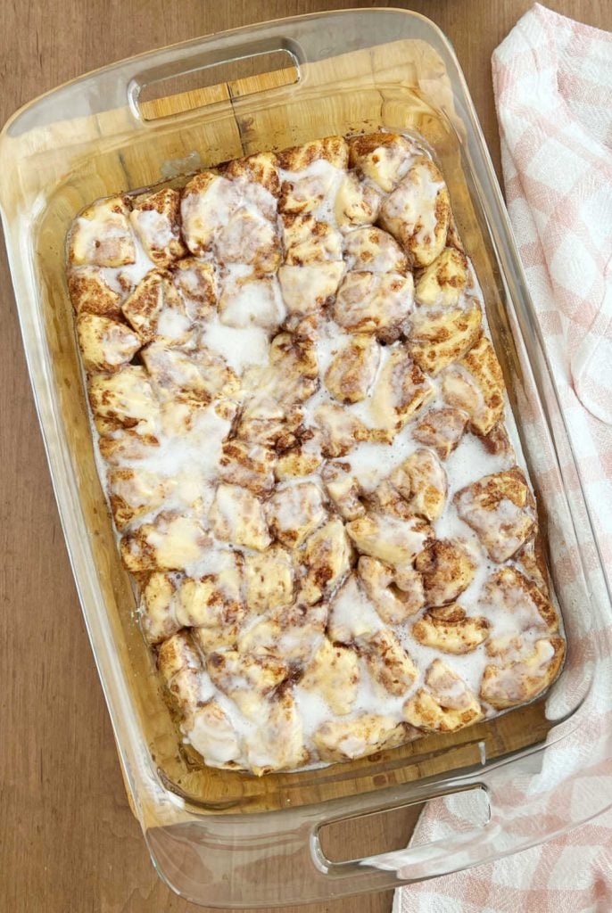 cinnamon roll breakfast bake with cream cheese frosting in baking dish