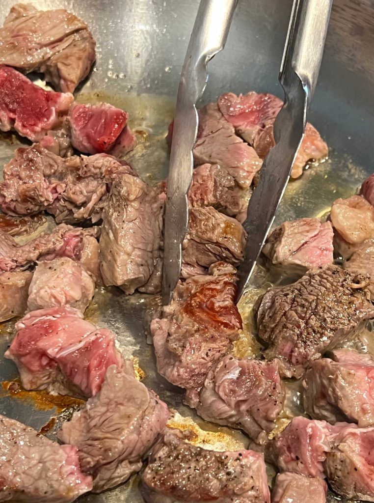 sear steak pieces in hot skillet