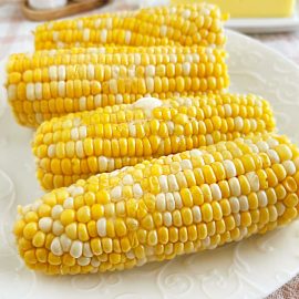 microwaved corn on the cob with melted butter on platter.
