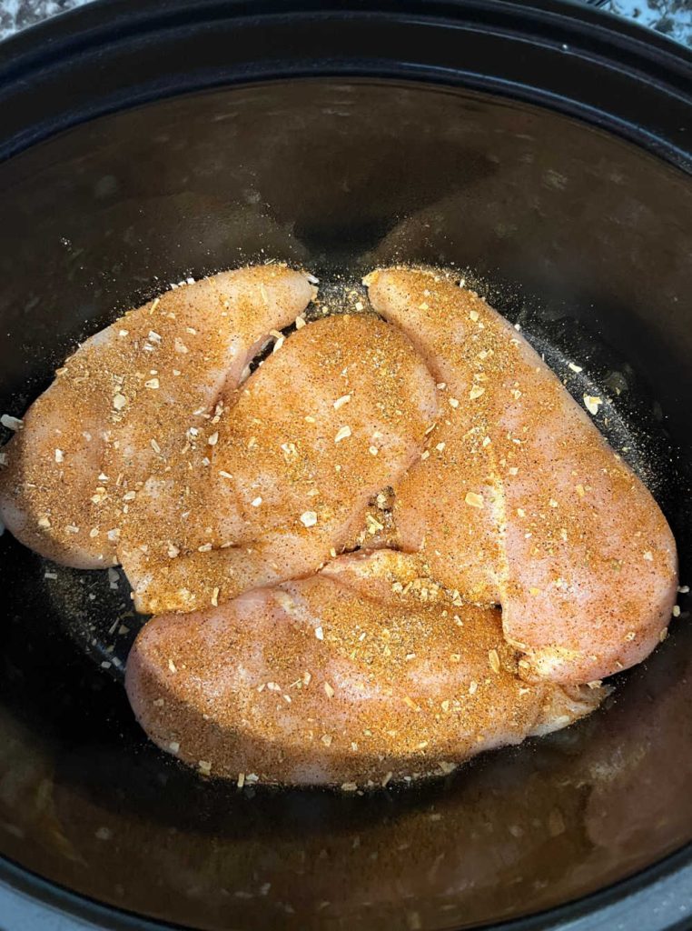 boneless chicken chicken breasts with taco seasoning in crock pot.