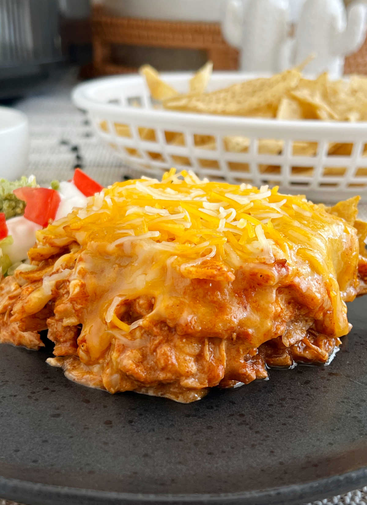 slow cooker enchilada casserole on black plate on table,