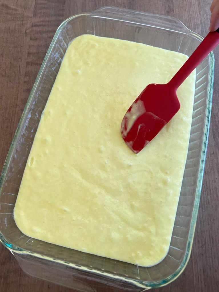 smooth cake batter in baking pan with spatula