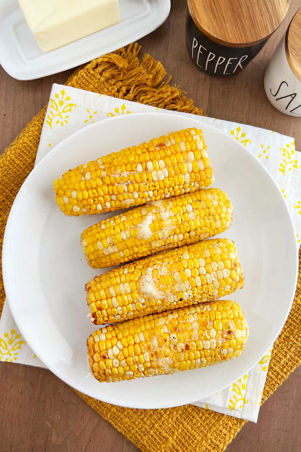 plate of air fryer corn on the cob with melted butter.