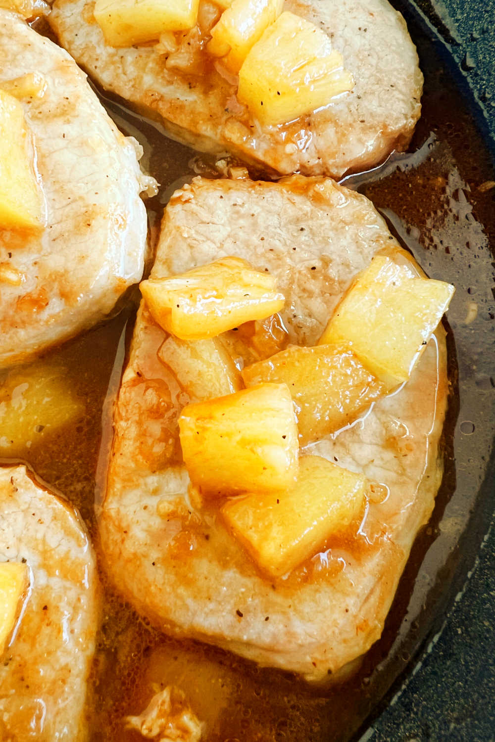 Hawaiian pork chops with pineapple in bbq sauce in skillet.