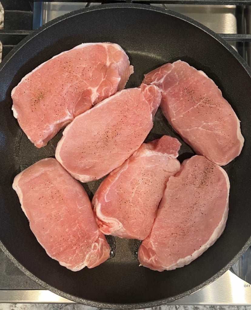 brown pork chops in skillet.