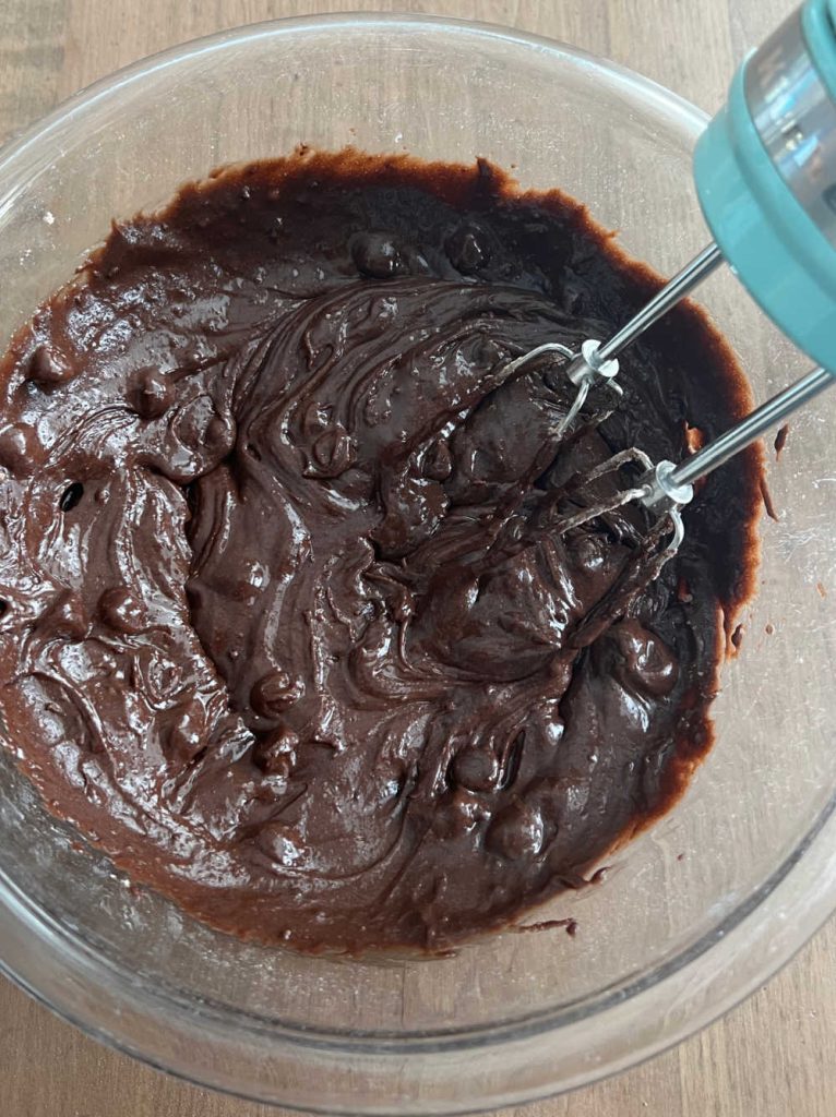 brownie batter in mixing bowl with electric mixer.