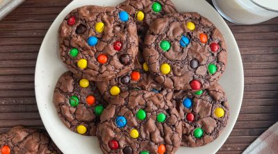 brownie mix cookies with mini m & m candies on a plate with milk.