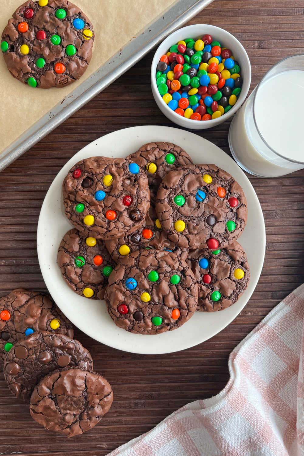 brownie mix cookies made with box of Ghirardelli triple chocolate brownie mix and mini m & m candies on plate with tall glass of milk.