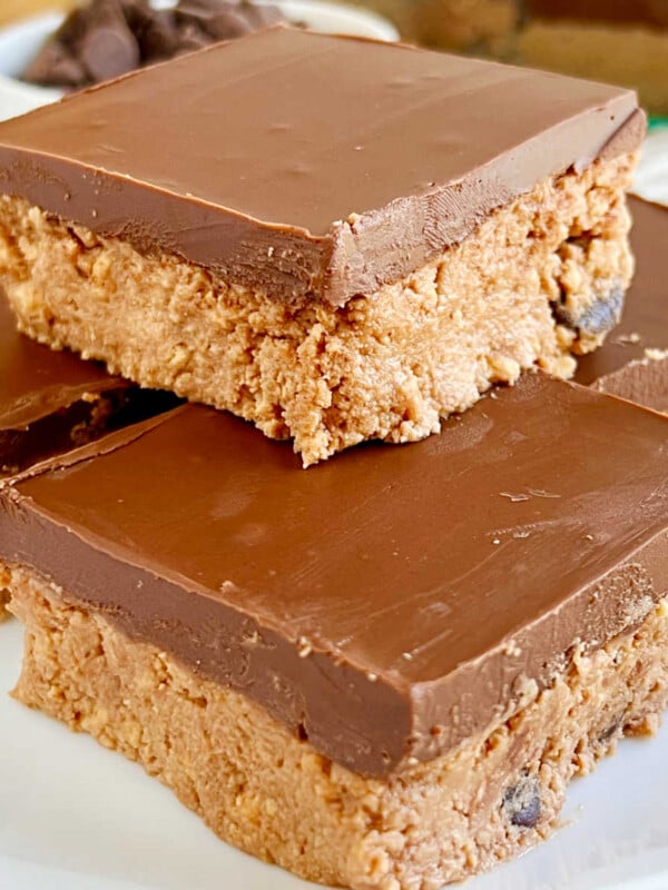 no bake chocolate peanut butter bars stacked on a plate.