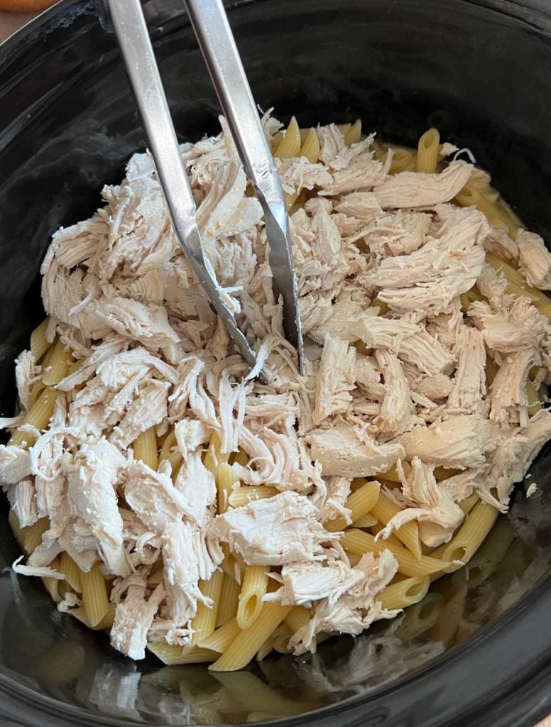 mix shredded chicken and cooked penne pasta in slow cooker.