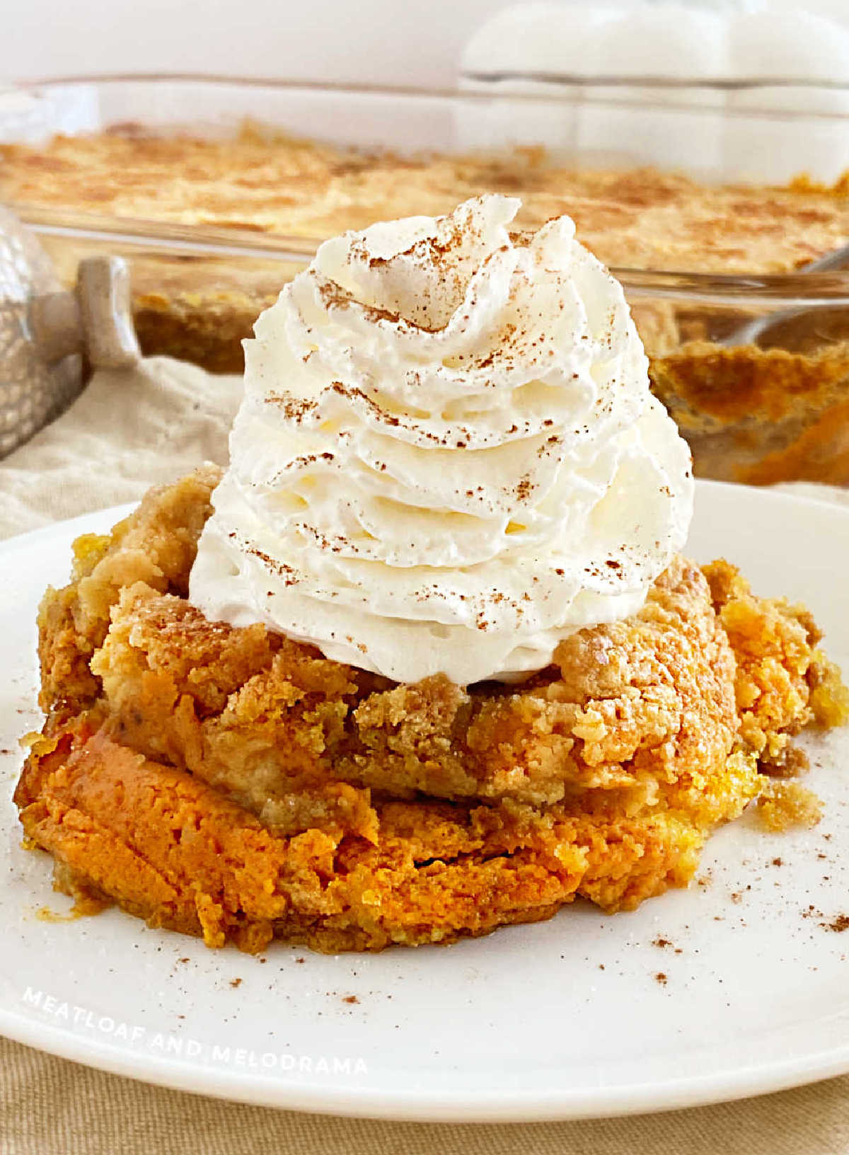 pumpkin pie dump cake on a plate with whipped cream.