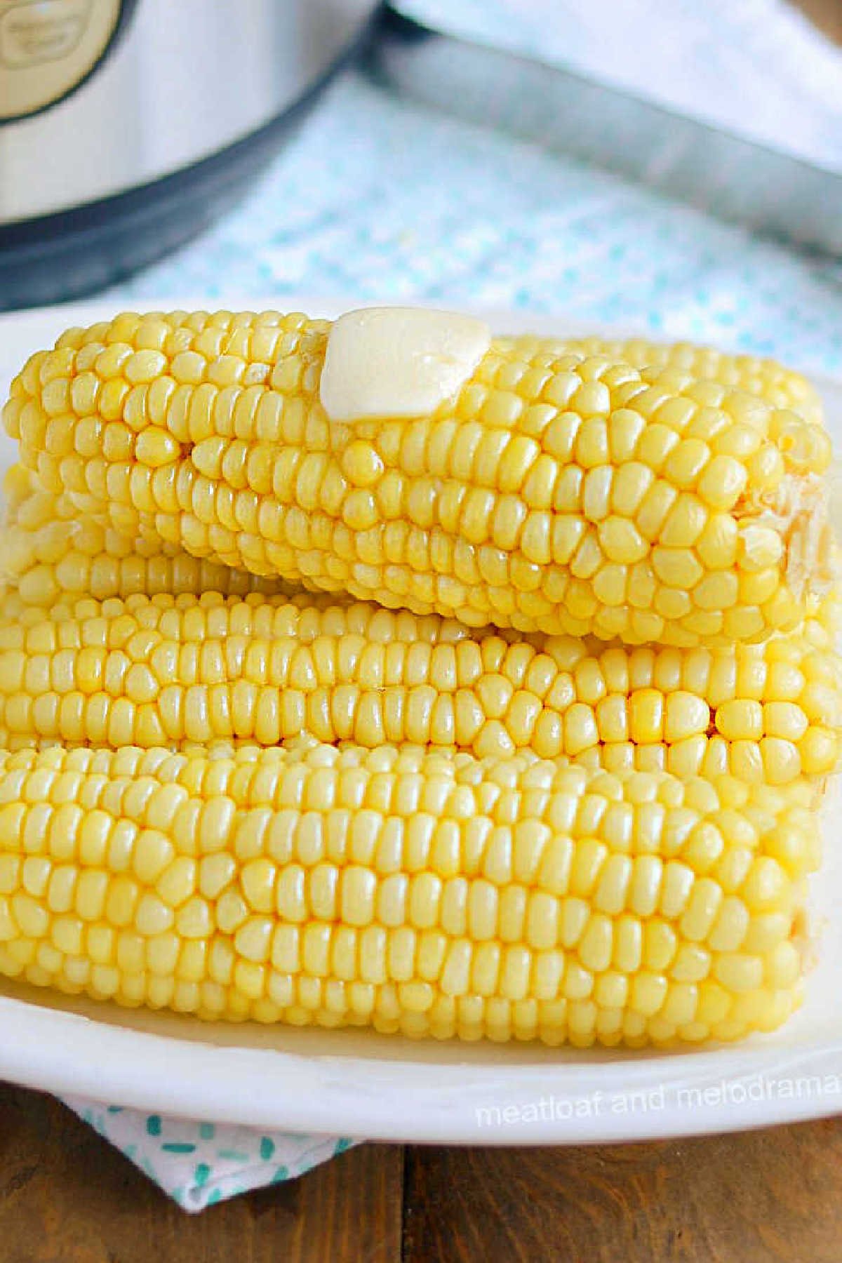 plate of instant pot corn on the cob with pat of butter on top.