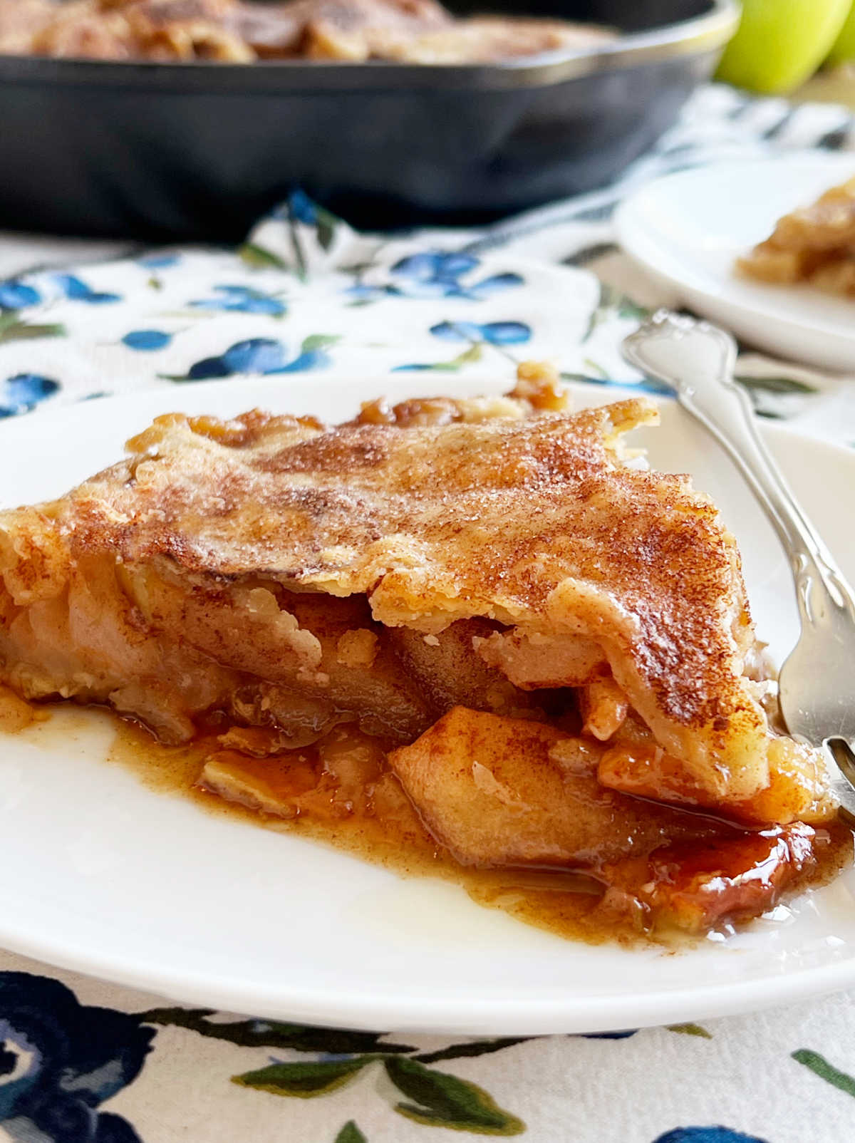 slice of apple pie in caramel sauce on plate.