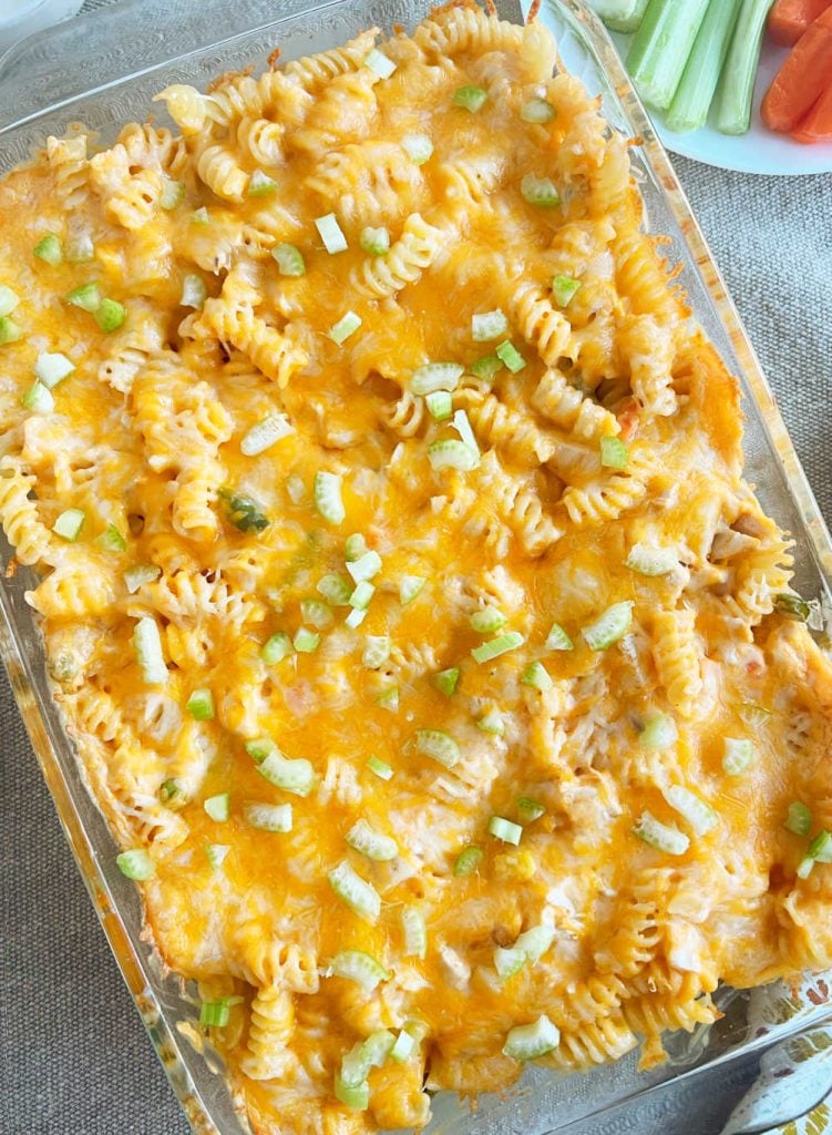 baked buffalo chicken casserole with melted cheese and chopped celery on table.