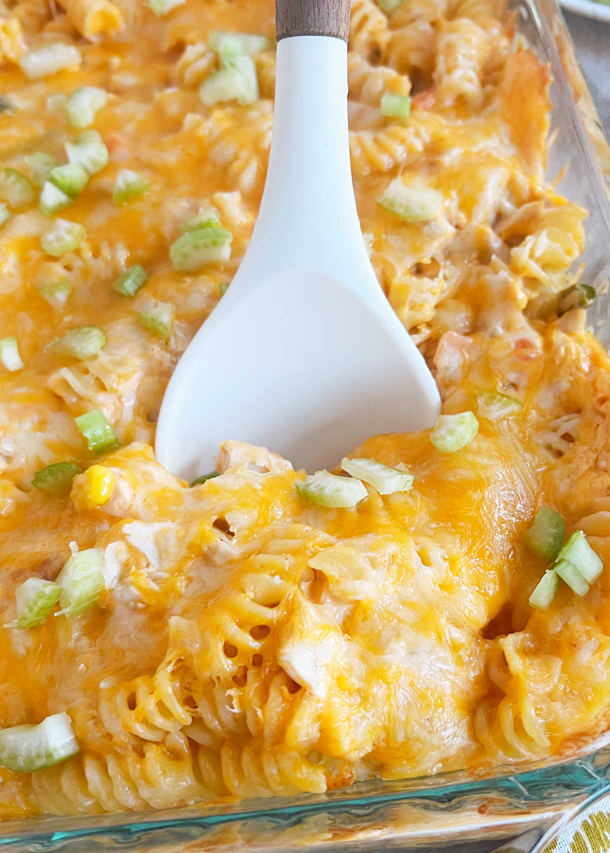 cheesy buffalo chicken pasta bake on white spoon.